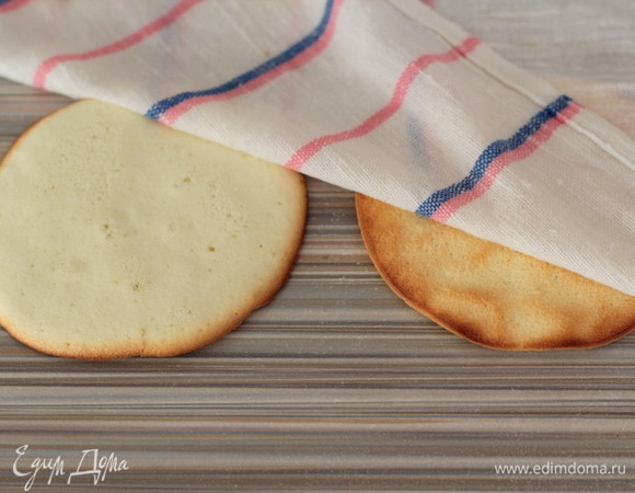 Выкладываем на стол и накрываем мокрым, хорошо отжатым полотенцем, чтобы они не засохли и хорошо гнулись. Если вдруг вы пересушили кружочки, то просто намочите чуть больше полотенце и дайте им полежать чуть подольше, до полного остывания. Готовим крем. В чашу добавляем творожный сыр Hochland, хорошо охлажденные сливки и сахарную пудру, взбиваем 3–4 минуты. Крем должен получиться густой и воздушный. Перекладываем его в кондитерский мешок.