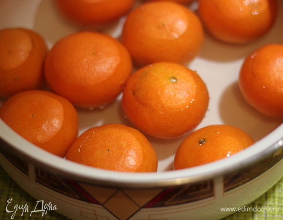 В большой кастрюле нагреваем воду, в кипящую закладываем мандарины и кипятим 5 минут, одновременно греем в чайнике воду. Сливаем воду и заливаем снова кипятком, кипятим 5 минут, сливаем и повторяем еще раз эту процедуру. Итого 3 раза мы заливали кипятком, кипятили и сливали. Таким образом мы убием горечь кожуры. После 3-го раза устраиваем мандаринам «шоковое охлаждение», после сливания кипятка опускаем их в ледяную воду и даем постоять 5–10 минут. Это позволит сохранить яркий цвет мандаринок.