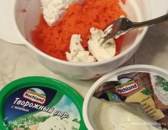 Морковь натереть на мелкой терке. Добавить половину упаковки творожного сыра Hochland. Посолить. Перемешать до однородной массы.