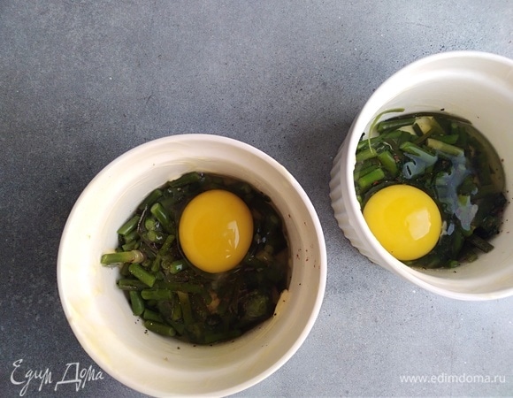 В каждую кокотницу разбить по 1 или 2 яйца.