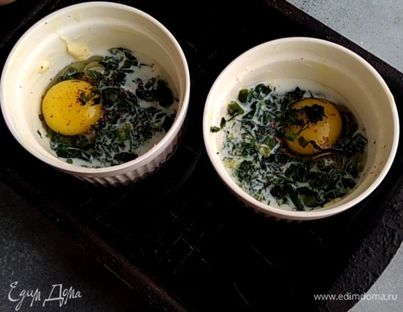 Духовку разогреть до 170°C. В форму для запекания поставить формочки, влить воду, чтобы она доходила до середины. Запекать 10 минут до жидкого желтка, 15 — до полностью приготовленного.