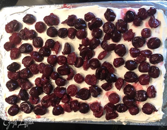 Далее смазать кремом и выложить вишню.