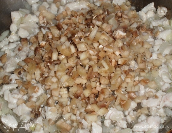 Затем добавляем нарезанные грибные ножки. Перемешиваем и обжариваем 3 минуты.