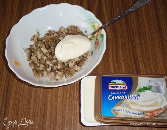 Курино-грибную массу выкладываем в чашку. Добавляем плавленый сливочный сыр Hochland и перемешиваем.