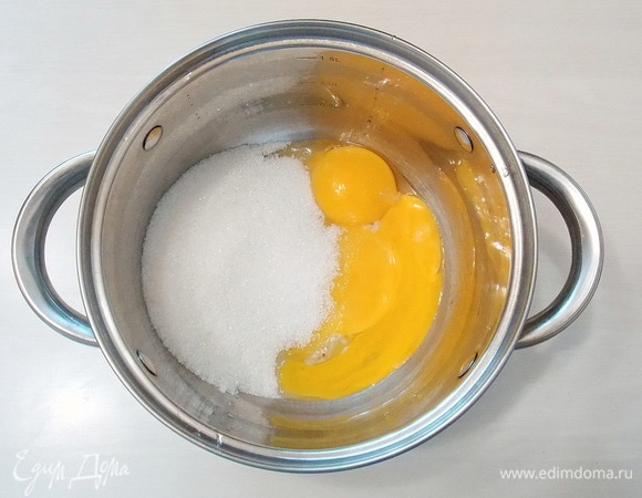 Отделим белки от желтков, белки пока отставим. В миску насыпаем половину сахара и добавляем желтки. Растираем до пышной белой массы.