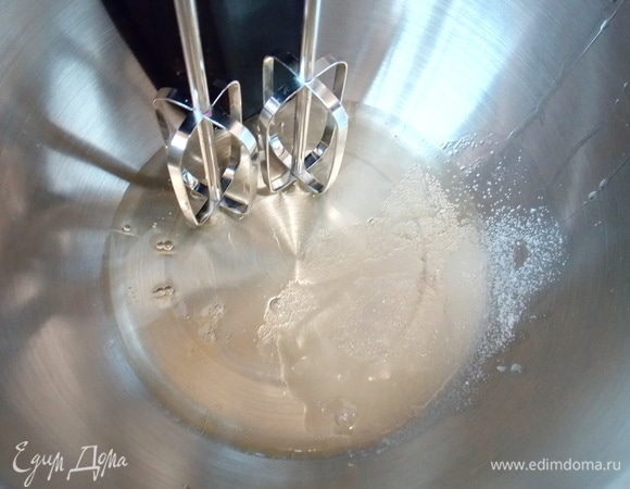В чашу блендера выливаем отложенные белки, добавляем щепотку соли и взбиваем до пышной пены. Затем постепенно всыпаем оставшийся сахар и продолжаем взбивать до плотной пены.