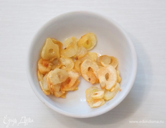 Перекладываем обжаренный чеснок в миску.