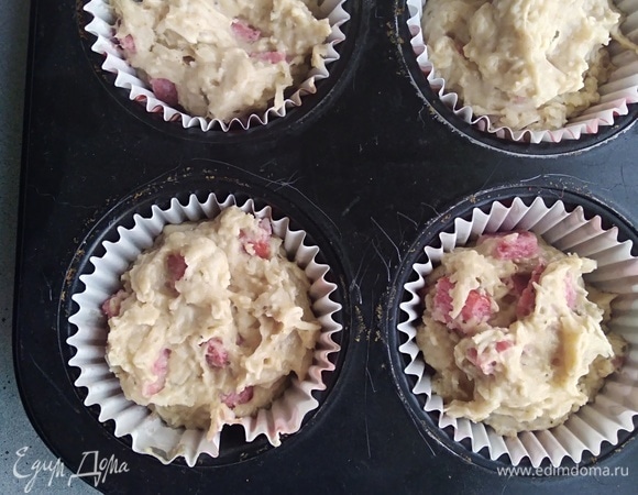 Духовку разогреть до 180°C. В ячейки для кексов вложить бумажные капсулы. У меня форма на 12 штук. Наполнить их тестом на 2/3. Выпекать 25 минут до сухой палочки.