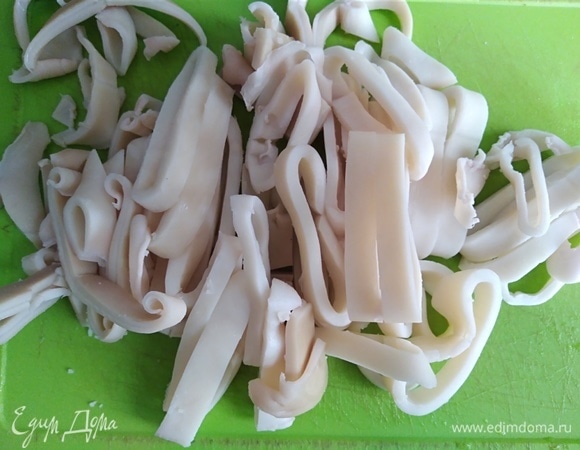 Кальмары (у меня охлажденные) отварить в подсоленной воде 5 минут. Слить воду, почистить и нарезать колечками. Дольше 5 минут варить их не стоит, будут резиновыми и невкусными.