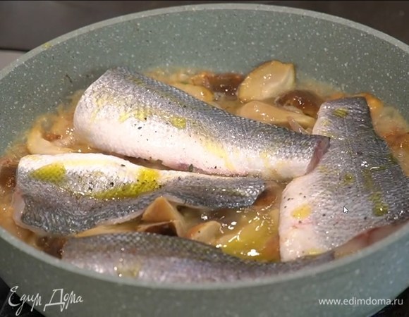 Филе сибаса выложить на грибы чешуей вверх, посолить, поперчить, сбрызнуть оливковым маслом, влить вино, накрыть сковороду крышкой и довести рыбу почти до готовности.