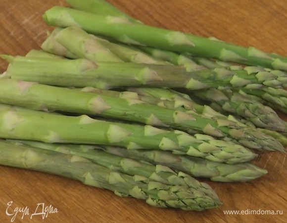 Спаржу, удалив грубые черенки, разрезать пополам.