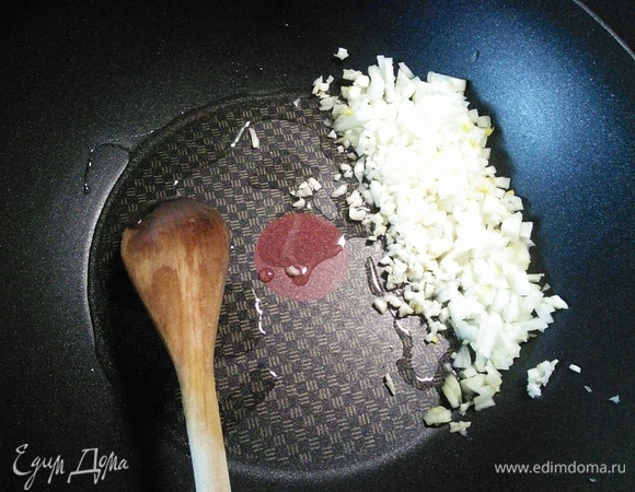 Очистить лук и чеснок и мелко нарезать кубиками. Разогреть подсолнечное масло и обжарить лук и чеснок до прозрачности.