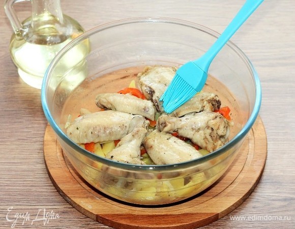 Курицу с овощами аккуратно выложила из пакета. Кусочки курочки положила сверху и смазала растительным маслом. Поставила формочку в СВЧ-печь. Установила режим «Гриль-2» и время жарки. Время я устанавливала по степени покрытия румяной корочкой, минут 5.