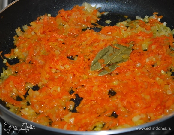 На растительном масле обжарьте морковь, потертую на крупной терке, и нарезанный лук. Добавьте один лавровый лист. Обжарьте все вместе до золотистого цвета.