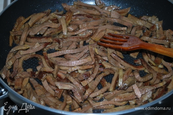 Отварной говяжий язык нарежьте соломкой и обжарьте на сковороде, где обжаривали грибы, в течение 2–3 минут.