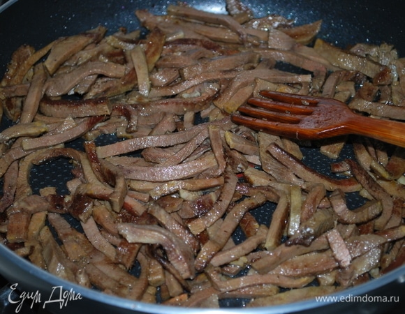 Отварной говяжий язык нарежьте соломкой и обжарьте на сковороде, где обжаривали грибы, в течение 2–3 минут.