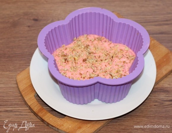 Выкладываем творожное тесто на корж и посыпаем просушенными и измельченными на сухой сковороде орехами.