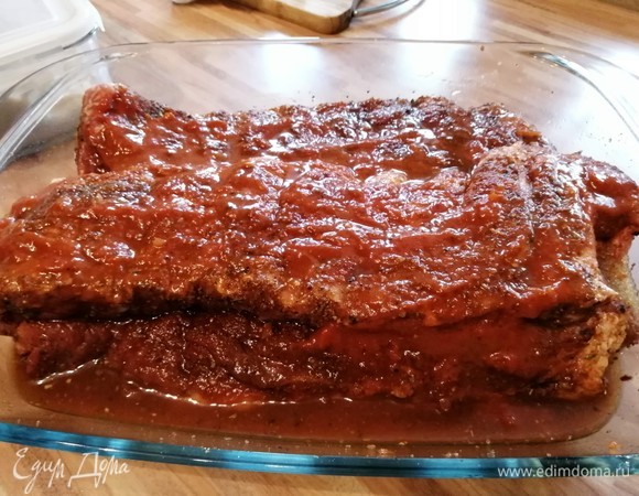 Ребрышки залить колой (наполовину емкости) и смазать соусом барбекю, посыпать коричневым сахаром, накрыть форму фольгой. Запекать в духовке при 80–100°C до 6 часов.