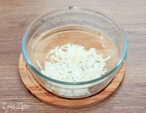 Очищенные лук и чеснок мелко нарезаем, выкладываем в большую миску и перемешиваем с растительным маслом.