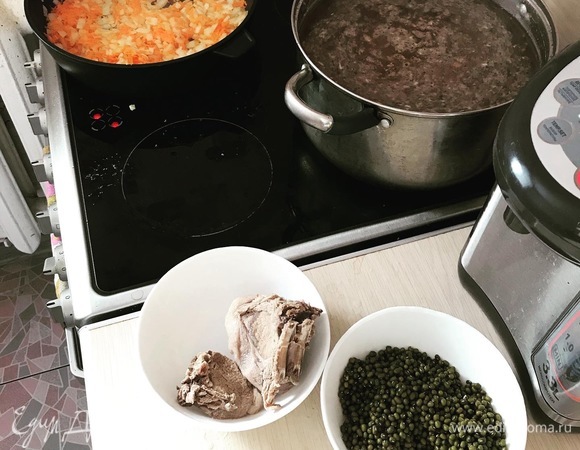 Подготовка завершена. Наливаем 5–7 литров воды в кастрюлю, доводим до кипения и кидаем туда кабана. И варим на сильном огне час. Классики рекомендуют процеживать бульон, но я считаю, что для аромата дичи лучше просто регулярно снимать пену. Вынимаем мясо охладиться, закидываем в бульон травы (базилик, чеснок, сушеные томаты) и доводим до кипения. В это время традиционно на масле обжариваем лук и морковь. Параллельно мелко-средне режем кабанчика.