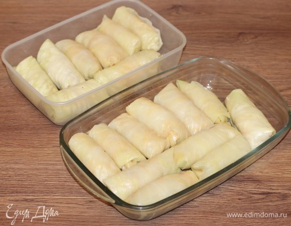 Сформируем голубцы. Кладем на более плотную часть капустного листа начинку и заворачиваем ее рулетиком — примерно на один оборот. Потом подгибаем внутрь открытые края и заворачиваем до конца. У меня получилось вот такое количество голубцов. Половину голубцов я отправила в морозилку (на потом), а половину выложила в смазанные маслом формочки для СВЧ-печи.