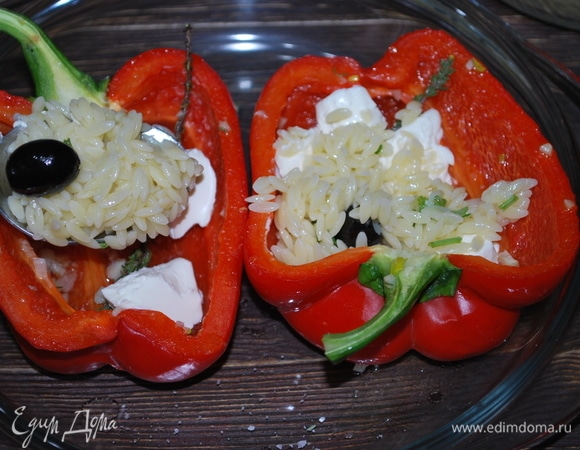 Достаньте перец из микроволновой печи. Перец, приготовленный таким образом, получается очень сочным, с легкой хрустинкой. На дно каждого перчика выложите пару кусочков творожного сыра, а сверху — начинку из макарон.