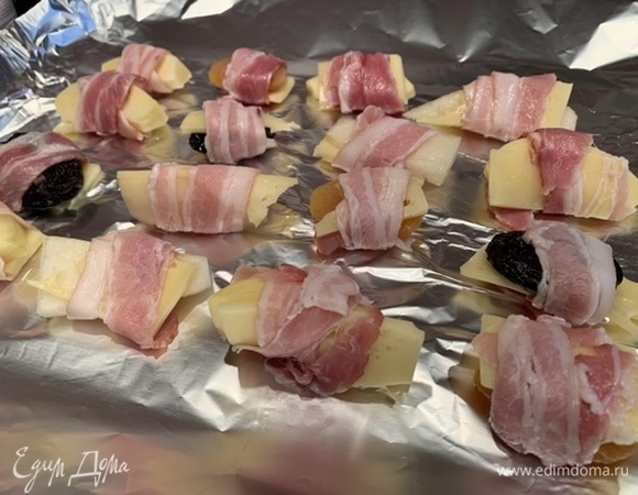 Выложите все такие рулетики на противень и запекайте в предварительно разогретой до 180°C духовке 10–15 минут, пока не подрумянится бекон.