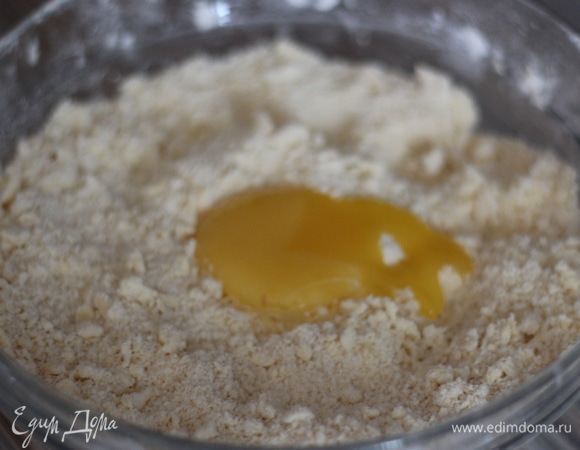 Добавляю желток и 2 ст. л. холодного молока. Собираем тесто в шар и немного промешиваем до однородности. Если тесто плохо собирается и рассыпается, добавьте еще ложку молока, но не больше!
