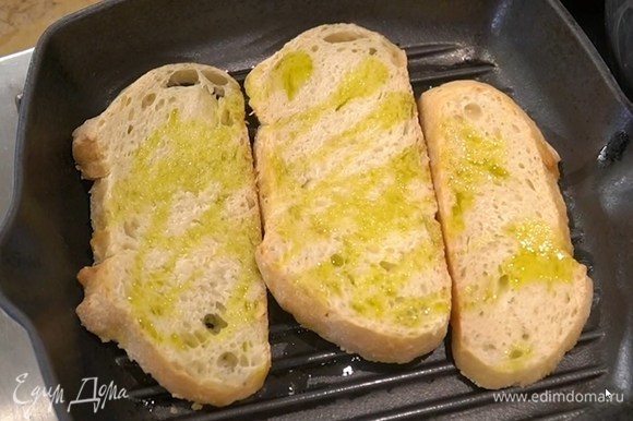 Хлеб сбрызнуть с двух сторон 1‒2 ст. ложками оливкового масла и обжаривать на сковороде-гриль до появления румяных полосок.