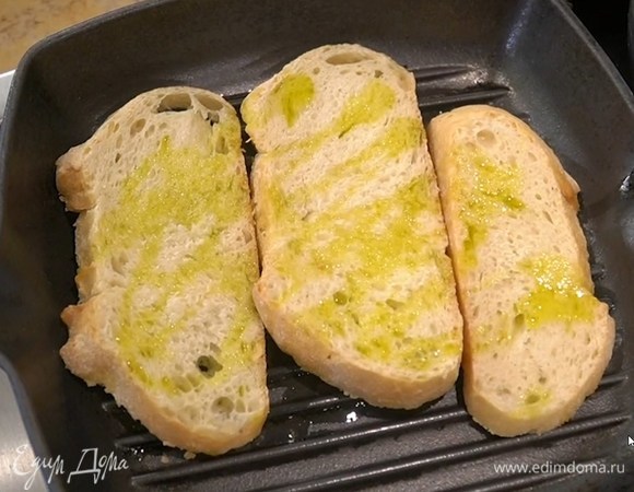 Хлеб сбрызнуть с двух сторон 1‒2 ст. ложками оливкового масла и обжаривать на сковороде-гриль до появления румяных полосок.