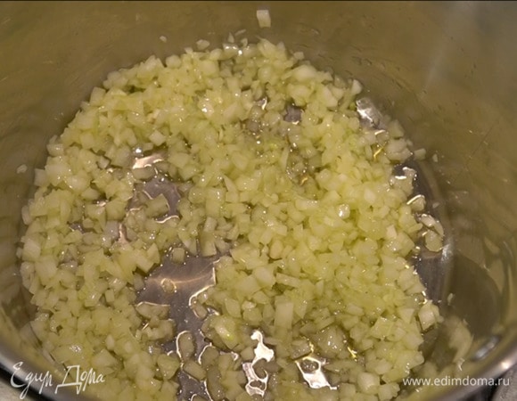 Разогреть в тяжелой глубокой кастрюле оливковое масло и томить в нем лук пару минут.