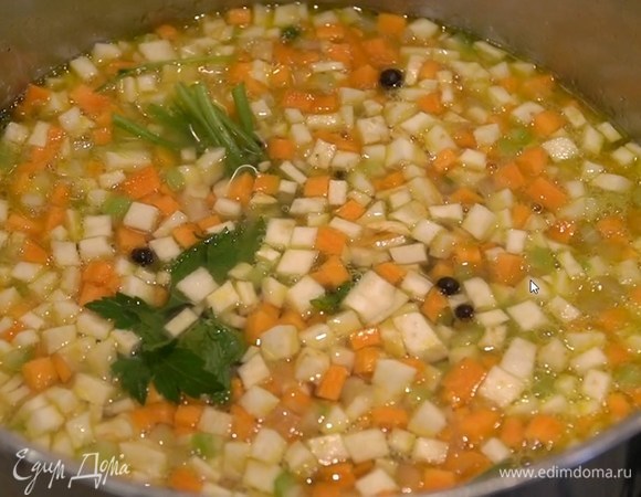Корень сельдерея и морковь почистить и нарезать маленькими кубиками, стебли сельдерея мелко порезать, выложить все к луку с чесноком, перемешать и залить кипящей водой так, чтобы овощи были покрыты, затем добавить соль, перец, можжевельник и пучок петрушки (пару веточек оставить). Накрыть крышкой и варить на маленьком огне часа полтора, подливая по мере необходимости горячую воду.
