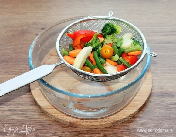 Воду сливаем, овощи выкладываем в сито.