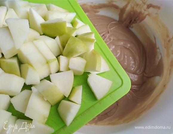 Яблоки очистить от шкурки или не очищать, по желанию. Нарезать кубиками. Вмешать в тесто. Духовку разогреть до 180°C.