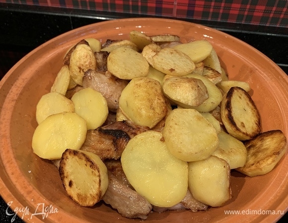 Картофель нарежьте и обжарьте на той же сковороде, где жарилась утка. Посолите. Выложите в тажин к утке.