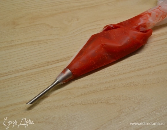 Готовим малиновый соус. Малину с сахаром нагреть. Крахмал развести небольшим количеством холодной воды. Малину пробить блендером, добавить крахмал, перемешать, вскипятить и варить около 1 минуты. Дать соусу остыть и переложить в кондитерский мешок. Убрать в холодильник.