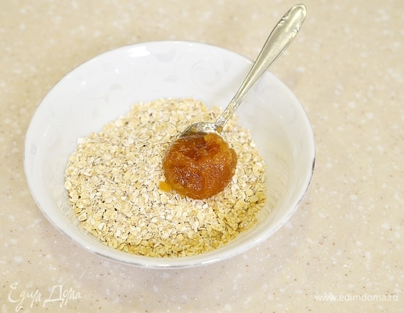 Хлопья насыпьте в миску, которую можно использовать в микроволновой печи. Добавьте мед.