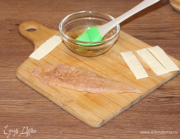 Смажьте каждый кусок отбитого филе масляной смесью.