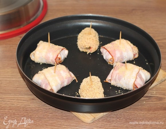 Затем аккуратно достаем прогретую емкость. Выкладываем рулетики, накрываем крышкой и отправляем в СВЧ-печь. Готовим (режим «Микроволны», 800 Вт) в течение 7 минут.