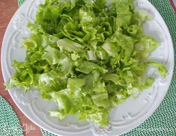 Листовой салат промыть холодной водой, обсушить и порвать руками на большую тарелку.