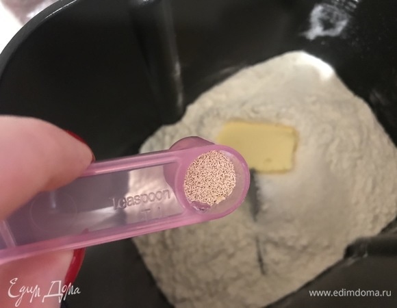 Добавить сливочное масло, влить воду и всыпать сухие дрожжи.