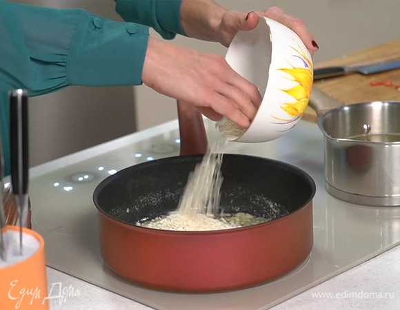 В сотейник добавить рис, обжарить, помешивая, в течение 2 минут — он должен стать полупрозрачным.