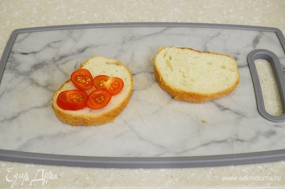 На один ломтик хлеба выложите с одной стороны нарезанные помидорки. Можно взять и большой помидор, тогда понадобится один кружок помидора.