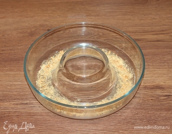 Форму для выпечки смазываем маслом и посыпаем панировочными сухарями. Я посыпала раскрошенным сахарным печеньем (2 шт). Заполняем формочку тыквенным тестом. Можно посыпать сверху тертым плавленым сыром — это по желанию.