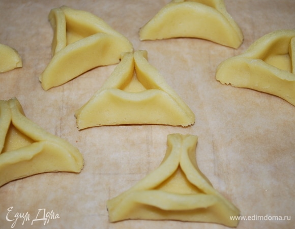 Защипните края теста с трех сторон, чтобы получилась шляпа (тесто хорошо прижмите с краев, чтобы при выпечке оно не разошлось). Выпекайте в разогретой духовке примерно 15 минут при температуре 160°C. Когда печенье будет готово, аккуратно достаньте его и дайте ему остыть (печенье очень нежное и хрупкое).