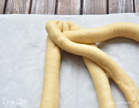 Жгуты соединить между собой сверху и начать заплетать в косу. Переложить в сторону 3-ий жгут и под ним перенести 1-ый. Все движения направлены вверх и в сторону.