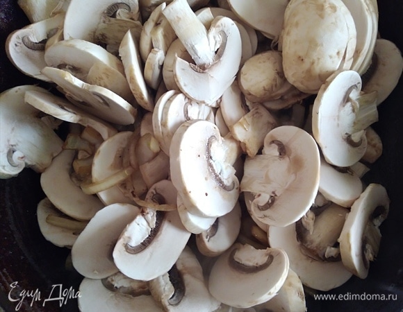 Шампиньоны нарезать пластинками и добавить к луку. Влить еще ложку масла и готовить, помешивая, около 4–5 минут.