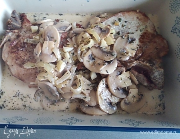 Влить сливки, дать закипеть. Переложить в форму для запекания мясо и соус с грибами. Духовку разогреть до 200°C.