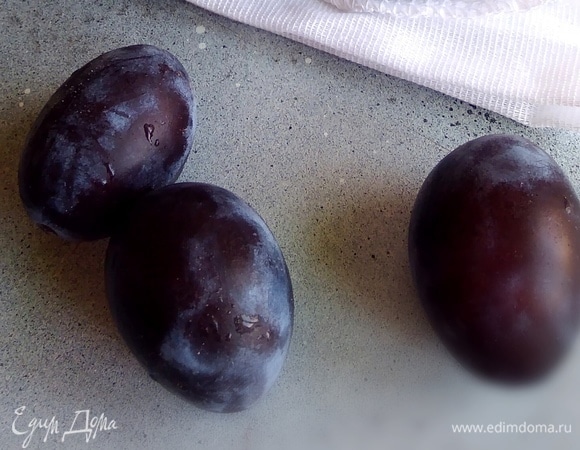 Сливу вымыть, разделить пополам, косточки удалить. Разложить половинки слив на пергамент близко друг к другу и смазать каждую маслом с помощью кисти.