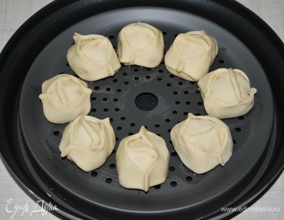 В емкость с водой установила подставку для приготовления на пару, смазала ее растительным маслом и выложила на нее манты.